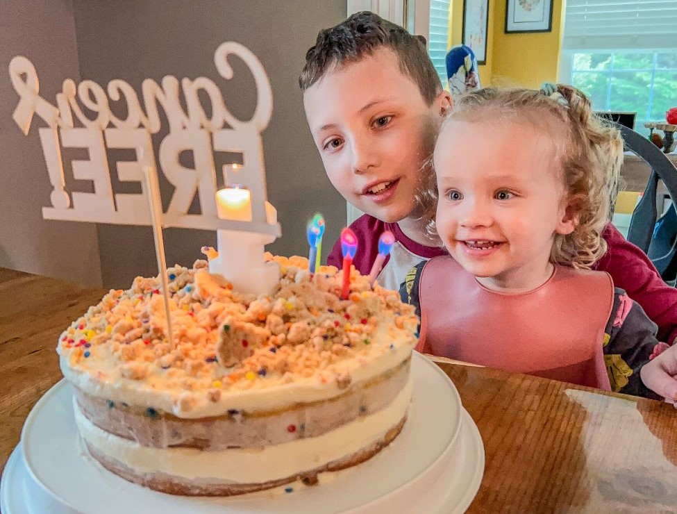 Remy celebrating being cancer free with a cake.